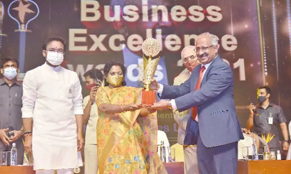 Telangana Governor Dr Tamilisai Soundararajan, presenting hmtv BEA lifetime achievement award to K Ravi, MD, NCL Industries.  Union Minister G Kishan Reddy was also present