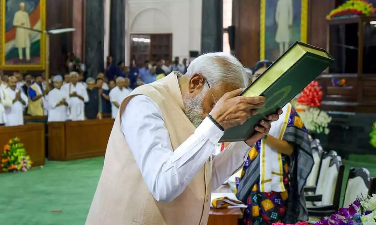 Prime Minister Narendra Modi pays respects to the Constitution of India as he attends the NDA Parliamentary Party meeting at Samvidhan Sadan in New Delhi on Friday