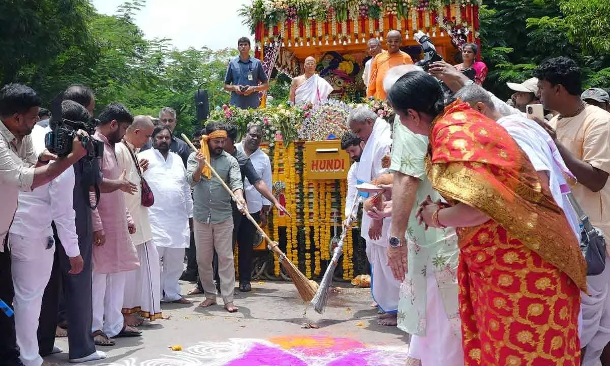 CM Revanth Reddy performing the Pahandi ritual, sweeping of the ground in front of the chariot in Hyderabad on Sunday