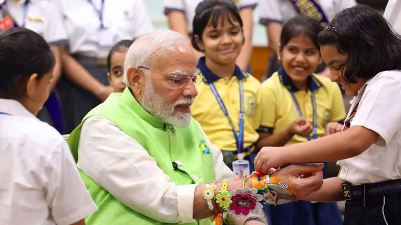 School children tie rakhis on Modi’s wrist